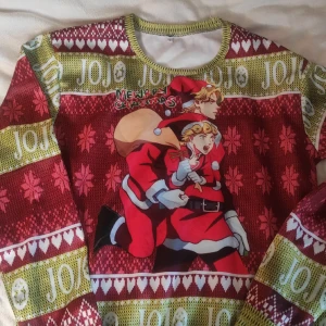 Jojo bizarre adventure jultröja - Detta är en jultröja i storlek L men skulle säga att den känns lite mer som en M.  Materialet är väldigt mjukt men det är mer som en vanlig tröja och inte stickad!
