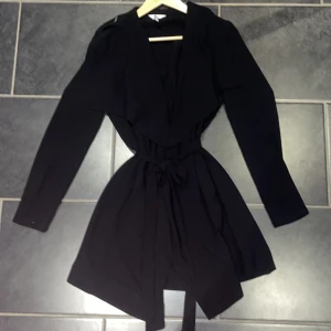 Trendig kappa - Jätte fin svart kappa aldrig använd fick i julklapp men aldrig använd inga skador eller fläckar alls finns varsin knapp på axlarna