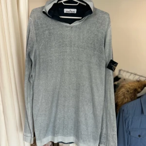 Stone Island Knit hoodie M - Grå stickad Stone Island hoodie i storlek M, den har små fläckar på nackdelen av luvan, som inte syns när luvan hänger. Samt en litet fel på axeln som inte heller syns. kolla bild 5! Annars fint skick!  Säljes då jag rensar garderoben