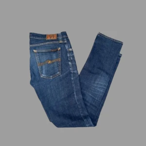 Nudie Jeans ”Tight Long John” - Säljer ett par feta mörkblå Nudie Jeans | passformen på byxorna är slimfit | storleken på byxorna är 32/34 | byxorna är lätt använda och i bra skick 9/10 | nypris är ungefär 1600 kr, vårt pris 400 kr | hör av dig vid frågor eller funderingar 💯