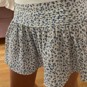 Blommig kjol - Jätte söt blå blommig kjol från Gina tricot. Den är lågmidjad och töjbart tyg. Den är i stl 158-162/xs-s. Säljer då den inte kommer till användning. Den är i bra skick💖