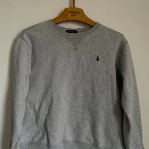 Grå Ralph Lauren Sweatshirt! - Sweatshirten är 14-16 år (155-165cm). Går absolut att förhandla. Mycket bra skick knappt använd 9/10. Perfekt till våren!