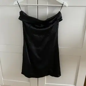 En superfin svart bandeau klänning med en liten slits från Ginatricot, aldrig använd med prislapp kvar! Nypris 399💗