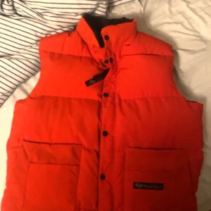 Canada goose väst S/M - Säljer min röda Canada Goose väst då den inte längre kommer till användning. Använd fåtal gånger och i perfekt skick. Nypris: 2500kr