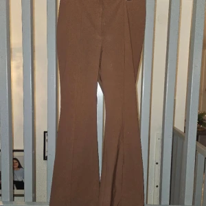 Sköna Flared Byxor - Härligt material som sitter som en smäck, blir inte skrynkligt eller noppigt. Använda vid ett tillfälle.  Trendig brun färg.  Strl 46.