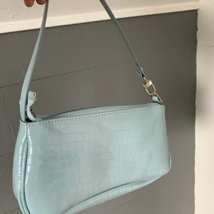 babyblå axelväska - babyblå axelväska med ormskinn liknande material. super fin och perfekt till en basic outfit för att få in lite färg också. lätt att ta med sig överallt!