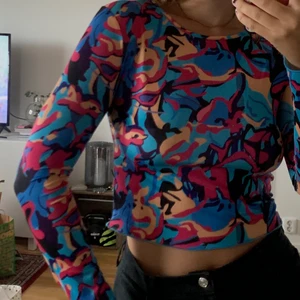 Färgglad croptop - Färgglad croptop med långa ärmar. I typ ”sport”material, sitter superfint på kroppen. I L men passar S-L beroende på önskad passform. 