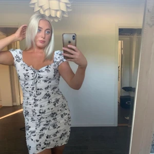 svart/vit sommarklänning  - Blommig sommarklänning använd 2 gånger, superfin till sommaren🤍🖤den ärnlitwt i storleken så sitter mer som en M!