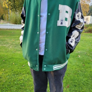 Herr hip hop baseballjacka - Säljer en Herr hip hop baseballjacka i grön och svart. Den passar en storlek S eller liten M.