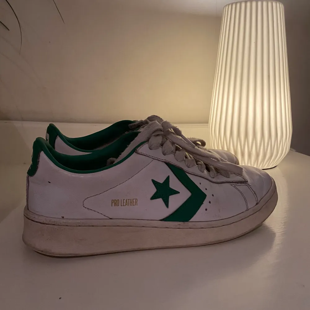 Vita Converse sneakers med gröna detaljer. Så fina och sköna att gå i! Inga större defekter förutom de slitage man kan förvänta sig. Storlek 40, köparen står för frakt🥰. Skor.