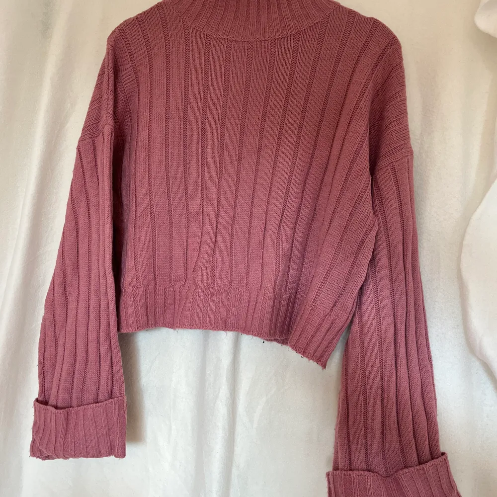Stickad tröja från boohoo med vida ärmar nedtill och lite polo. Tröjan är i en väldigt fin rosa/smutsrosa färg 😍. Stickat.