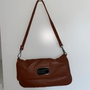 Marc Jacobs väska - Så fin Marc Jacobs väska som jag köpte på second hand. Får tyvärr inte användning av längre. Några mindre defekter men inget som syns därav det billiga priset. Finns även ett långt band man kan ha över kroppen ☺️