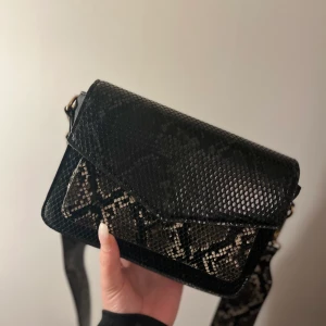 Glitter, väska fake skinn - Väska med fake skinn från glitter. Använd ett fåtal gånger. Utöver de bandet som redan sitter på väskan, får man 2 st svarta band som ligger i väskan. 