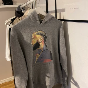 Nipsey Hussle hoodie - En Nipsey hussle hoodie i storlek M och färgen grå. Jag säljer den för 150kr plus frakt
