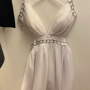 Vit klänning  - Säljer denna vackra klänning som jag haft på Bal och på midsommar. Använd 2 tillfällen. Storlek M, går att spänna lös eller tajta till ganska mycket så fungerar för S-L beroende på hur man vill att den sitter. Den är special beställd och betalt 1200:-. 