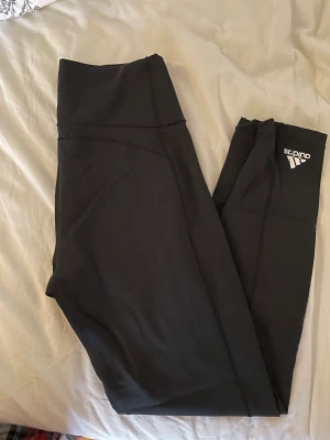 Adidas träningstights  - Adidas träningstights i storlek M. Har själv sytt dit 2 små hål så man kan ha snörning i midjan om man vill