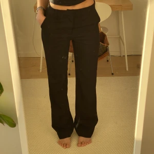 Svarta kostymbyxor  - Svarta kostymbyxor i modellen Fiona från Lindex. Midjemått: 75cm, Innerbenslängd: 84cm. Fraktar för 59kr eller möts upp i Lund.