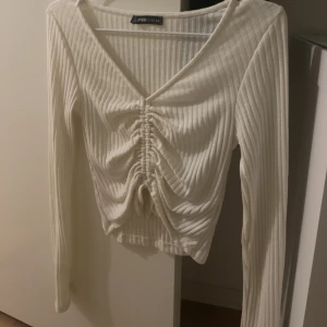 vit topp - Super snygg vit topp som är ribbad med veck o snören nertill