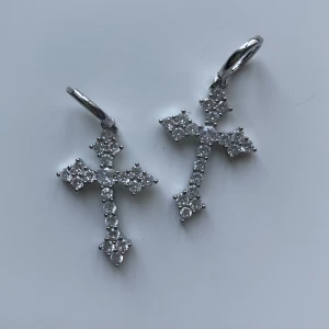 Kors örhängen  - Oanvända örhängen med kors, säljer då jag har många liknande. Osäker på materialet. Frakt tillkommer 