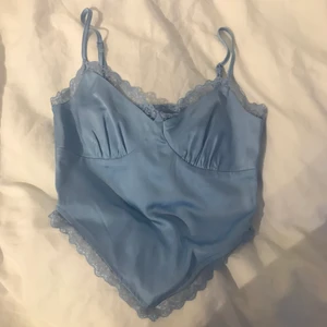 Linne från bikbok strl xs - Har aldrig använt. Jättefint blått linne som visar mage och väldigt mycket rygg med spaghetti-straps med lite spets