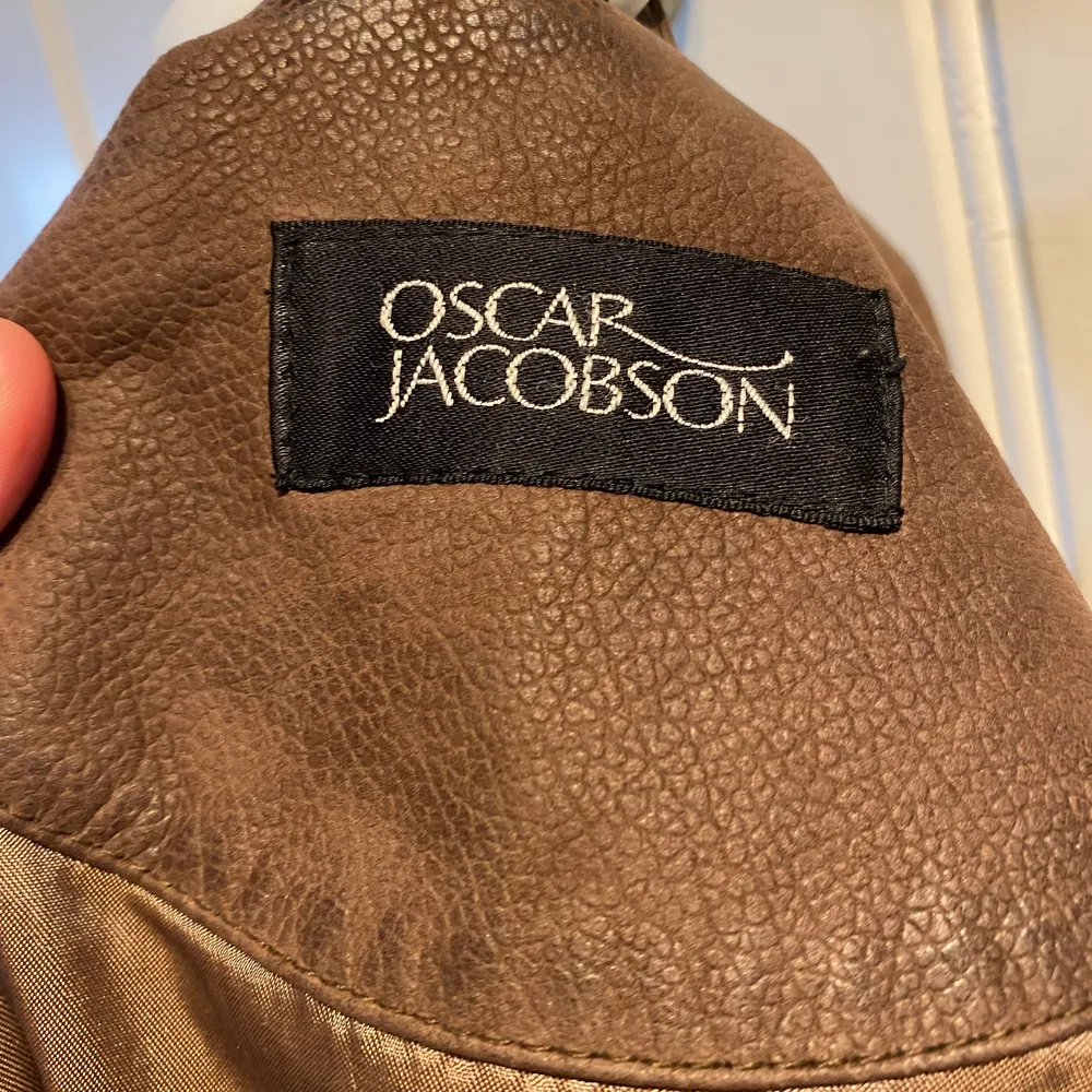 Här säljs en brun läderkappa från Oscar Jacobsson i storlek 50! Denna är ganska stor på mig som vanligtvis har S/M men passar jättebra om man vill ha oversized!  Aldrig använd eldstad provad för bild!. Jackor.