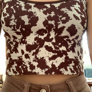 Fin komönstrad topp från urban outfitters - Fin ko topp, st xs, från urban outfitters, lagom i storlek, använd en gång och i bra skick.