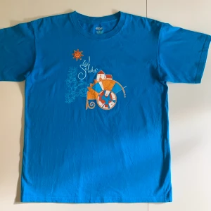 Vintage t-shirt turkos med retrotryck Large - Cool vintage t-shirt i superfin turkos färg.  Made in El Salvador. Oversized stil. Gjord av bomull och i bra skick.