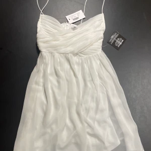Vit oanvänd klänning  - En vit oanvänd klänning från Nelly i st. 36