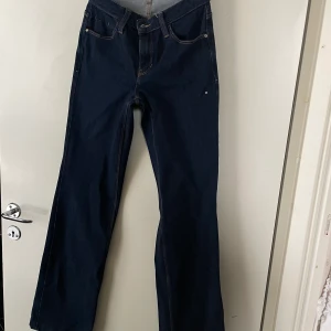 Guess jeans  - Guess jeans, typiskt lågmidjade 2000s byxor med utsvägning. Jeansen har en guld detalj på högrra bakfickan där det står guess och en kristall på vänstra höften och är i mycket bra skick!