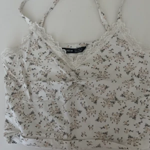 Blommigt spets linne shein - beiget blommigt spets linne från shein i strl Xs💕lite långa band men jag brukar bara knyta dom! Lite croppat ;)