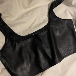 Lädertopp - Lädertopp från Nelly, nyskick. Storlek S, stretchig i materialet!🖤