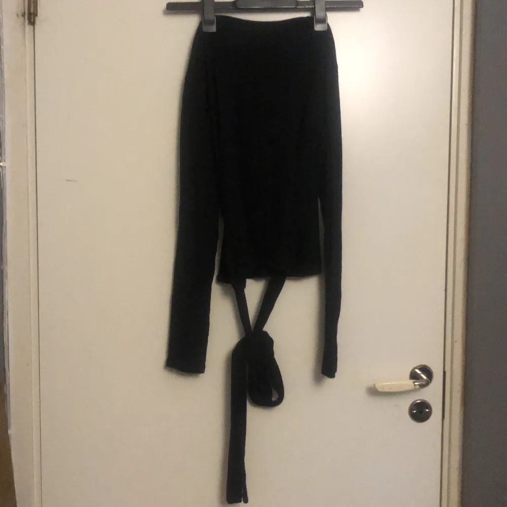 En tunn långärmad svart tröja med band som knyts i midjan från Zara.. Toppar.