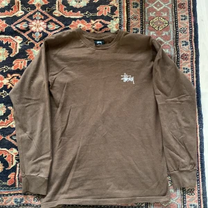 Stussy tröja  - Stussy brun tröja/ långärmad t-shirt.  Kvalitet: 6,5/10.  Bra kvalitet men har repor på Stussy-loggan på baksidan och lite på framsidan.  Sitter bra och materialet är av bra kvalitet.  Maila mig för att förhandla priset :)