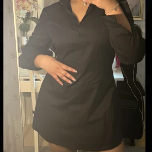 Skjortklänning - Svart skjortklänning med snöre, går att knyta framtill men även bakom som jag gjort på bilden💓 denna skjorta är väldigt oversized och går att knyta lösare🫶🏽