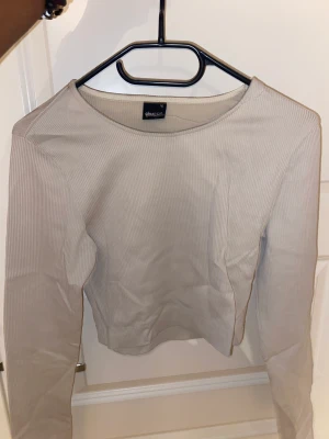Långärmad tröja  - En beige långärmad croppad tröja. 