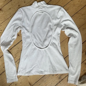 Vit polotröja med öppen rygg  - Vit polotröja med öppen rygg, vanligt tshirtmaterial (lite tjockare) och ribbad. Använd en gång.
