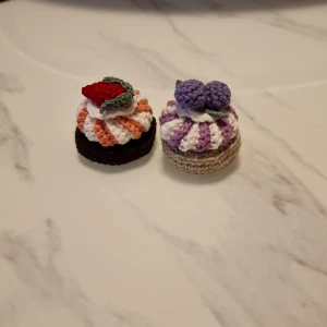Söta små virkade bakelser - Vikade bakelsef som jag gjort själv. Garnet är av bomull. Båda bakelsen för 65 kr Köparen står för frakten (29kr). 