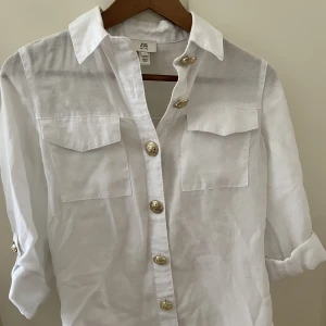 Skjortor  - Vit med guldknappar oanvänd pris 275kr strl 4/xs passar s, River island. Vit nyskick 170kr strl s, blå strl 34 120kr