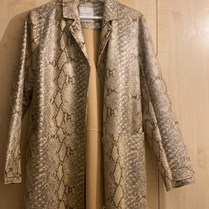 Beige ormskinn jacka - Bra skick, knappt använd. Fejk skinn. Strl 40 men liten i storlek. Super fin från märket Rino & Pelle