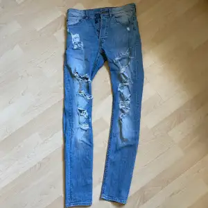 Jeans med skinnyfit och slitningar. Storlek 29 i midjan