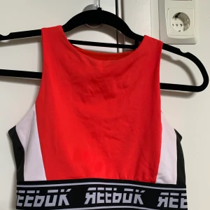 Träningstopp från Reebok.  - Träningstopp från Reebok.  Använd fåtal gånger, så i väldigt fint skick.   Den funkar att ha sportbh under om man vill! Kan bli väldigt snyggt i ryggen!!   Storlek M