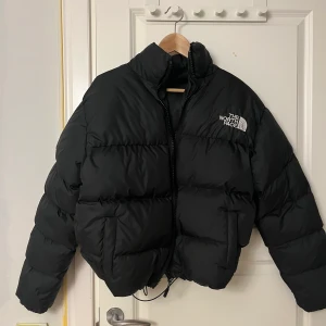 Croppad North face jacka  - Croppad North Face jacka. Storlek S. Snöret där man Croppar jackan har lossnat därav priset. Fortfarande jättesnygg o går säkert att fixa snabbt. Men har aldrig använt den