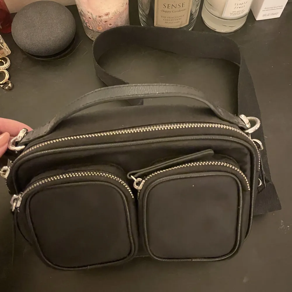 Svart handväska från H&M med ett stort fack och två små fack framme på väskan. Justerbart band så den kan vara både kortare och lite längre!. Accessoarer.