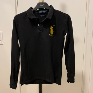 Pikétröja  - Säljer min pikétröja i bra skick. Fina detaljer i gul/guld. Passar XS och S.