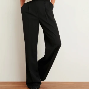 NAKD kostymbyxor - Svarta kostymbyxor från NAKD. Sitter helt perfekta, ganska vida i benen. Uppsydda till att passa runt 1.60-1.65. Frakt tillkommer!