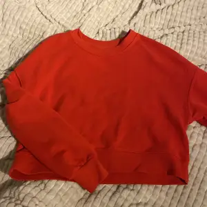 en röd fin sweatshirt, använd men skön å fint material. lite kort i magen men inte som en magtröja❤️