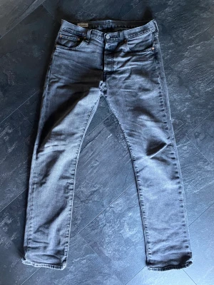 Levis 501 Jeans - Hej, säljer ett riktigt snygga Levis jeans i modellen 501. Som ger en perfekt passform på jeans, är väldigt fina för att varit använda.  Är mörk grå färg (syns bäst på sista bilden) och i storlek 30/32.  Om frågor eller fler bilder hör gärna av dig. 