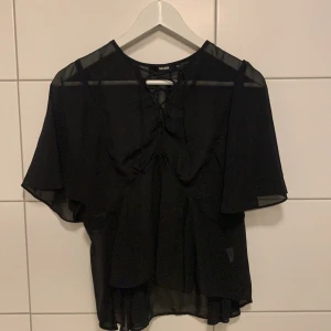 Blus med snörning  - Fin transparent blus med snörning. Bra skick