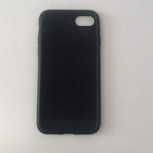 Ett skal till en iPhone 7. Skalet är svart och är i gummi. 