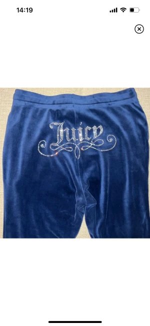 Juicy Couture Mjukisbyxor - Juicy byxor i nyskick med rhinestones. Flared och storlek M! Finns inte att köpa i butik längre. Kommer tyvärr aldrig till användning, så säljer dem!